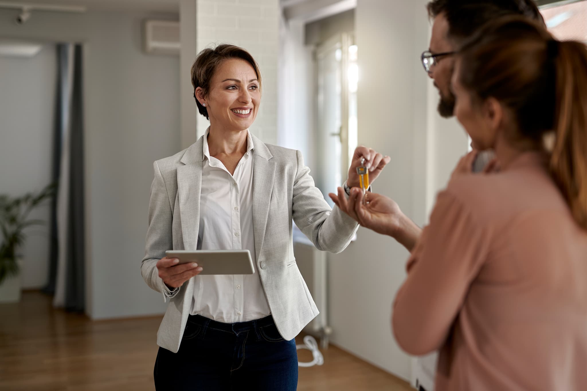 Real estate agent handing keys to a couple in their new home