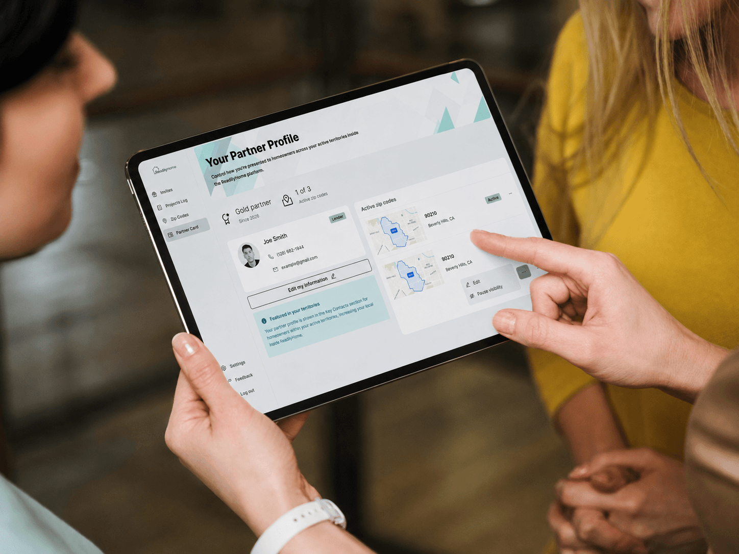 Two people reviewing a ReadilyHome partner profile on a tablet