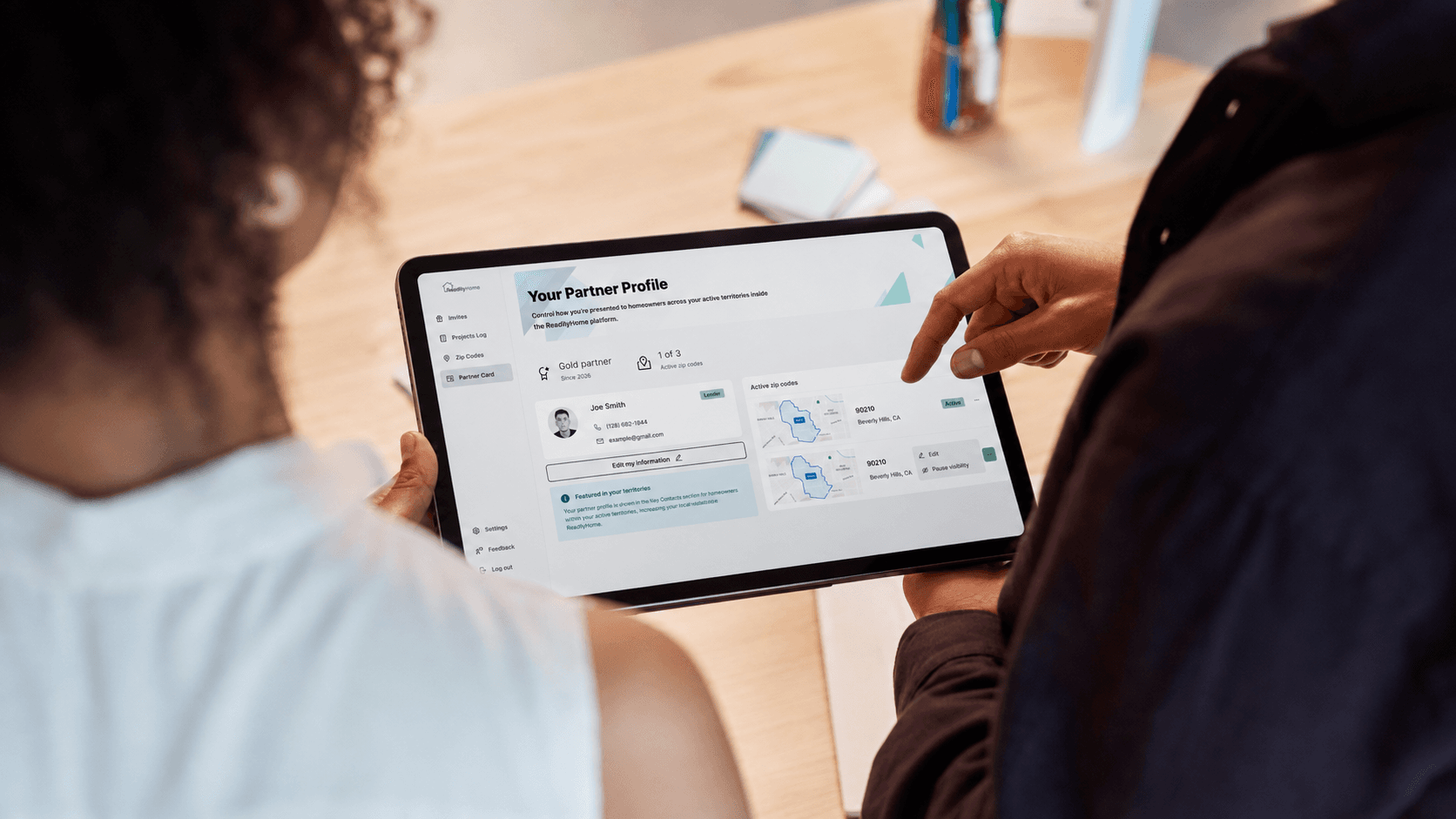 Two people reviewing a ReadilyHome partner profile on a tablet